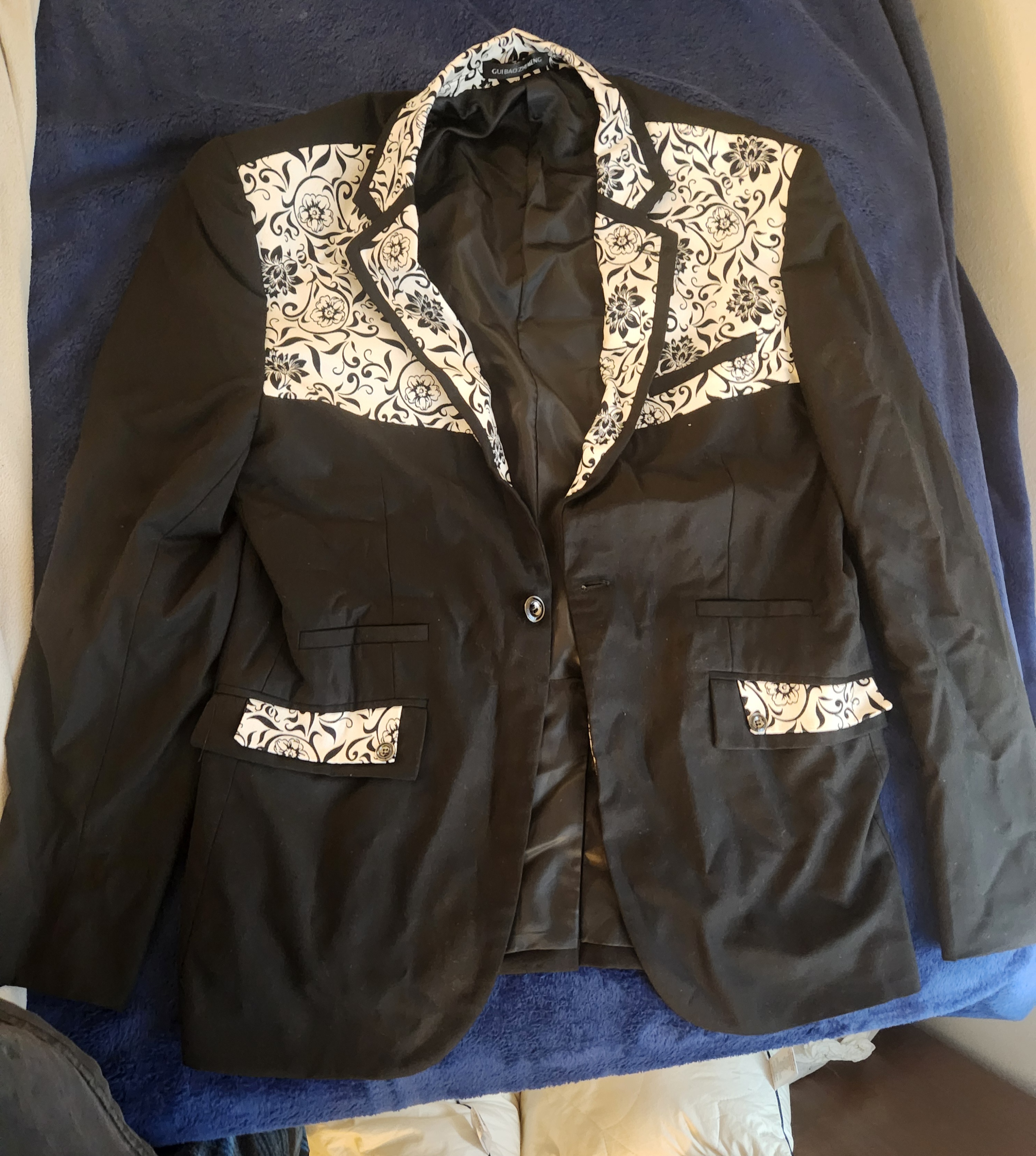 Black jacket with black floral on white background on collar and lapel with black lining